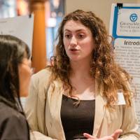 Tabor Gleason explaining her research to a professor